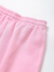 Close-up of pink high-waist elastic waistband with reinforced stitching on jogger pants