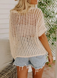 Detail of hollow-out knit pattern on beige crochet top with breathable mesh texture