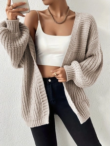 Close-up of beige knit cardigan with vertical texture and stylish puff sleeves design