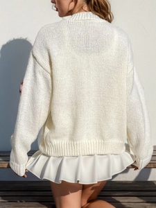 Détails d'un cardigan blanc en maille texturée avec un ourlet élégant à volants