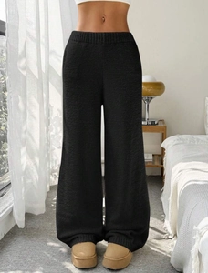 Macro shot of high-waist ribbed waistband and textured knit fabric on black wide-leg pants