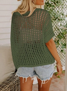 Close-up of army green hollow knit mesh fabric with ribbed edges on a beach cover-up
