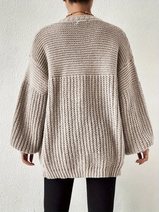 Detailed back view of oversized beige knit cardigan showing thick texture and lantern sleeves