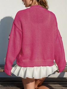 Vue détaillée du gilet en maille rose rouge avec ourlet à volants blancs superposés