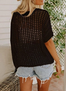 Detail of black hollow out knit top featuring square mesh weave and lightweight texture