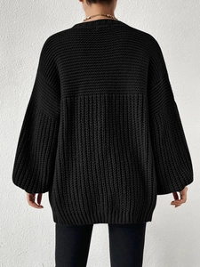 Rear view of black chunky knit oversized cardigan with ribbed hem and balloon sleeves