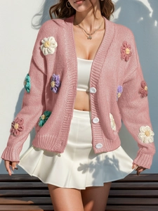 Gros plan détaillé du cardigan rose à col en V avec fleurs au crochet 3D et boutons blancs