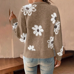 Détail du cardigan en maille montrant le motif marguerite et les poignets côtelés