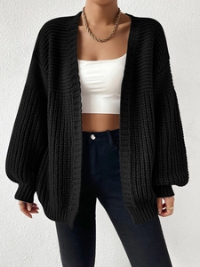 Detail of chunky knit texture and loose fit drop shoulder on black women's cardigan