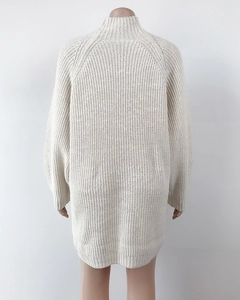Detailed back view of an oversized cream knit sweater dress with a high neckline