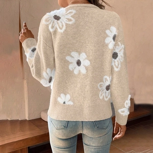 Détail du pull en maille florale avec des motifs marguerites blanches et textures pelucheuses