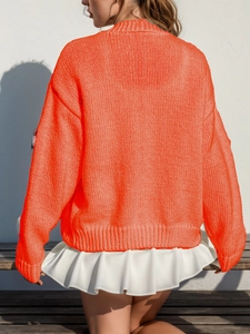 Détail du dos d'un cardigan orange fluo en maille épaisse avec bords-côtes et col V