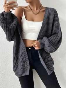 Detail of dark grey chunky knit cardigan featuring oversized lantern sleeves and thick texture
