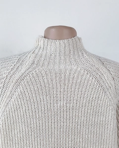 Detailed close-up of beige mock neck raglan sleeve sweater with thick knit texture