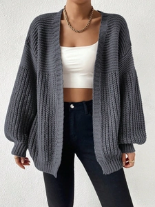 Detail of dark grey chunky knit cardigan with ribbed texture and lantern sleeves