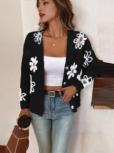 Gilet noir chic à motifs floraux blancs et boutons argentés avec un jean en denim