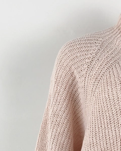 Close-up of pink knit sweater detailing soft thick yarn texture and shoulder seam