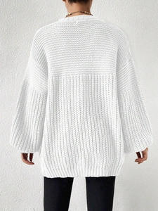 Close-up detail of white chunky knit sweater texture with oversized ribbing pattern
