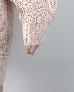 Close-up of pink chunky knit sweater showing detailed ribbed cuff texture and soft fabric