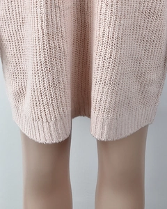 Detail of light pink knit dress featuring textured rib-knit hem and high-quality fabric