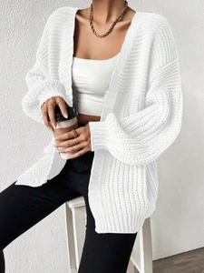 Detailed view of the chunky knit pattern on a white oversized long sleeve cardigan