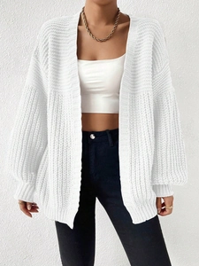 Close-up of white chunky knit cardigan texture with detailed vertical stripe patterns