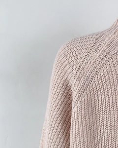 Close-up of pink knit sweater showing raglan sleeve texture and detailed stitching