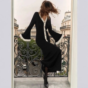 Détail de la robe en maille à col en V avec liseré contrasté et boutons dorés au balcon