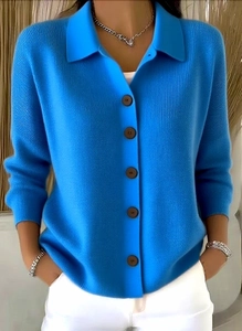 Detail der leuchtend blauen Strickjacke mit Polo-Kragen und braunen Knöpfen aus Holzoptik