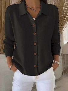 Close-up of black knit cardigan featuring brown buttons and vertical ribbed texture