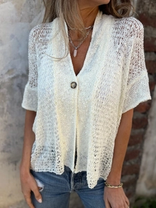 Close-up of white crochet hollow-out knit cardigan with V-neck and single button detail