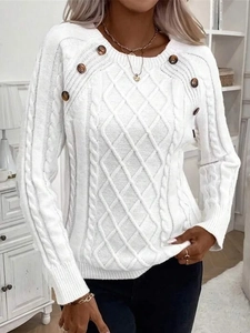 Detailed cable knit pattern on white sweater with decorative buttons on shoulders
