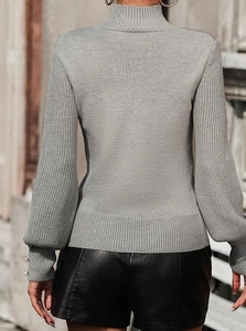 Detail of grey ribbed knit sweater featuring elegant lantern sleeves and pearl cuff buttons