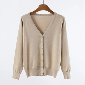Macro detail of V-neck cardigan featuring fine knit texture and matching buttons