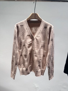 Detailed close-up of light pink V-neck knit cardigan showing vertical rib patterns