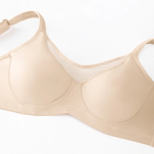 Detail view of beige plus size bra showing mesh stitching and adjustable straps