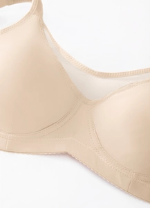 Detail of a nude seamless bra showing sheer mesh panels and fine reinforced stitching