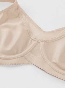 Detail of beige full-figure bra showing breathable mesh fabric and delicate lace trim