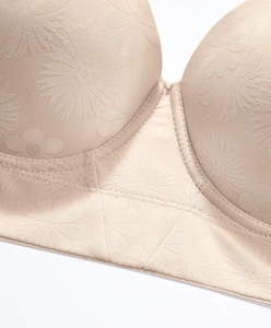 Gros plan sur le tissu jacquard floral et les coutures renforcées d'un soutien-gorge beige