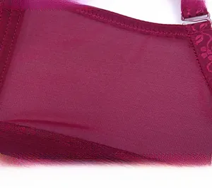 Macro detail of wine red lace bra featuring wide mesh side wings and seamless stitching