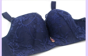 Detailed close-up of dark blue lace bra featuring floral patterns and a teardrop gemstone