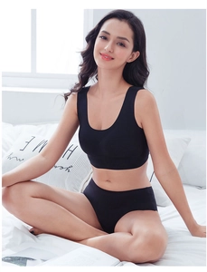 Seamless black sports bra set in breathable fabric shown in a cozy home setting