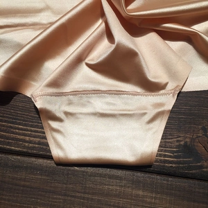 Détail macro de culottes en satin champagne sans couture avec coutures de haute qualité