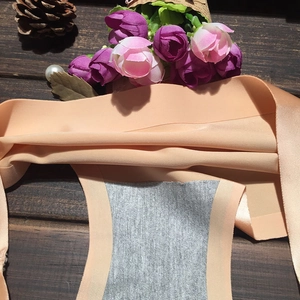 Gros plan sur la culotte sans couture rose-orange montrant l'entrejambe gris respirant