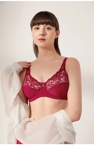 Lace detail of a burgundy full cup bra with silver heart pendant and floral pattern