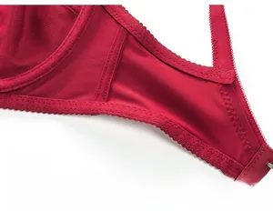 Detail of wide side wings on red lace bra showing reinforced stitching and smooth fabric