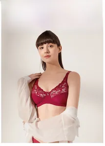 Close-up of deep red lace bra with floral patterns and a small heart metal pendant