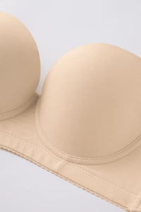 Close-up of seamless nude plus size bra with scalloped edges and reinforced stitching