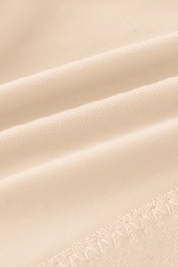 Close-up of the beige honeycomb knit fabric texture and high-quality overlock stitching detail