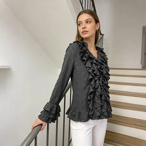 Detail of ruffled cuffs and pleated texture on a black French style blouse
